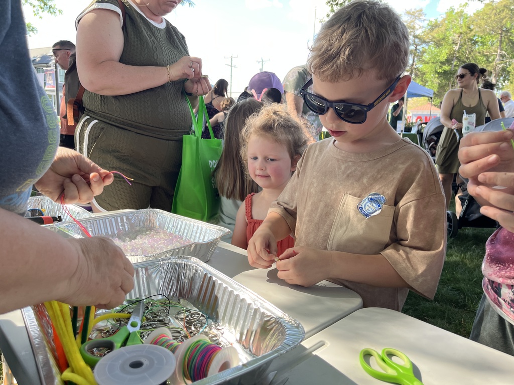 A family visits a booth at an Eartyh Day Festival. 