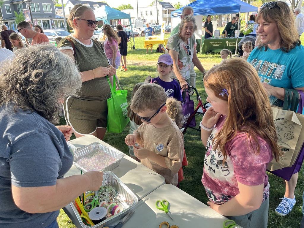A family visits a booth at an Eartyh Day Festival. 
