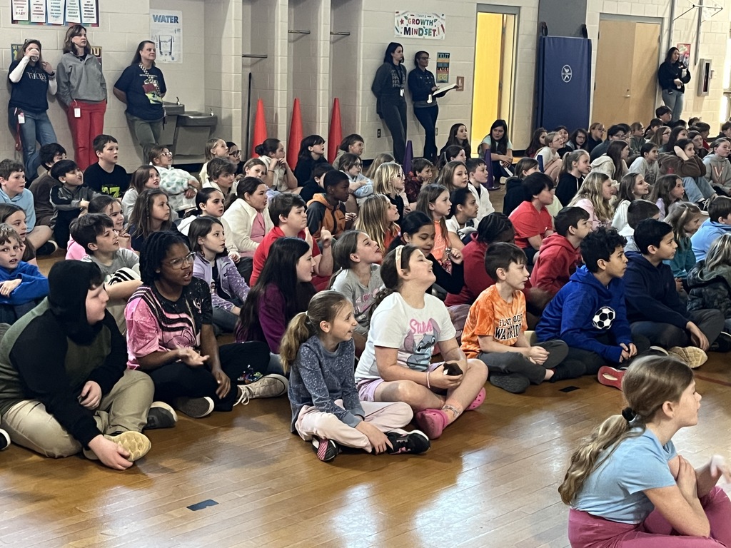 Students participate in  a school assembly in an elementary gym with an African storyteller.