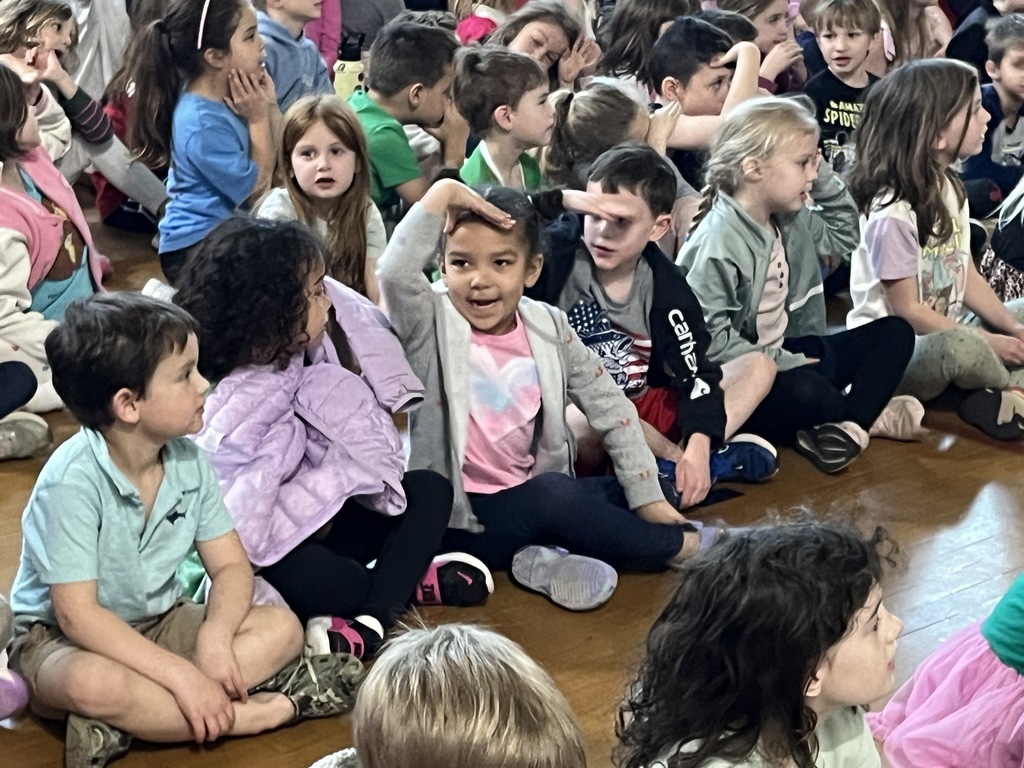 Students participate in  a school assembly in an elementary gym with an African storyteller.