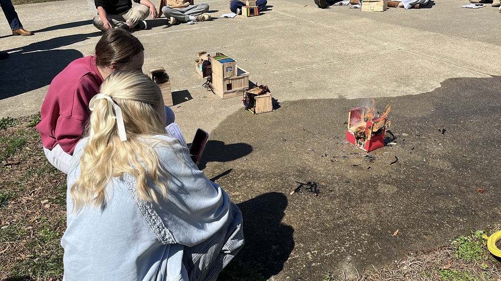 Students observe a burning popsicle house as part of a unit on arson in their forensic science class.