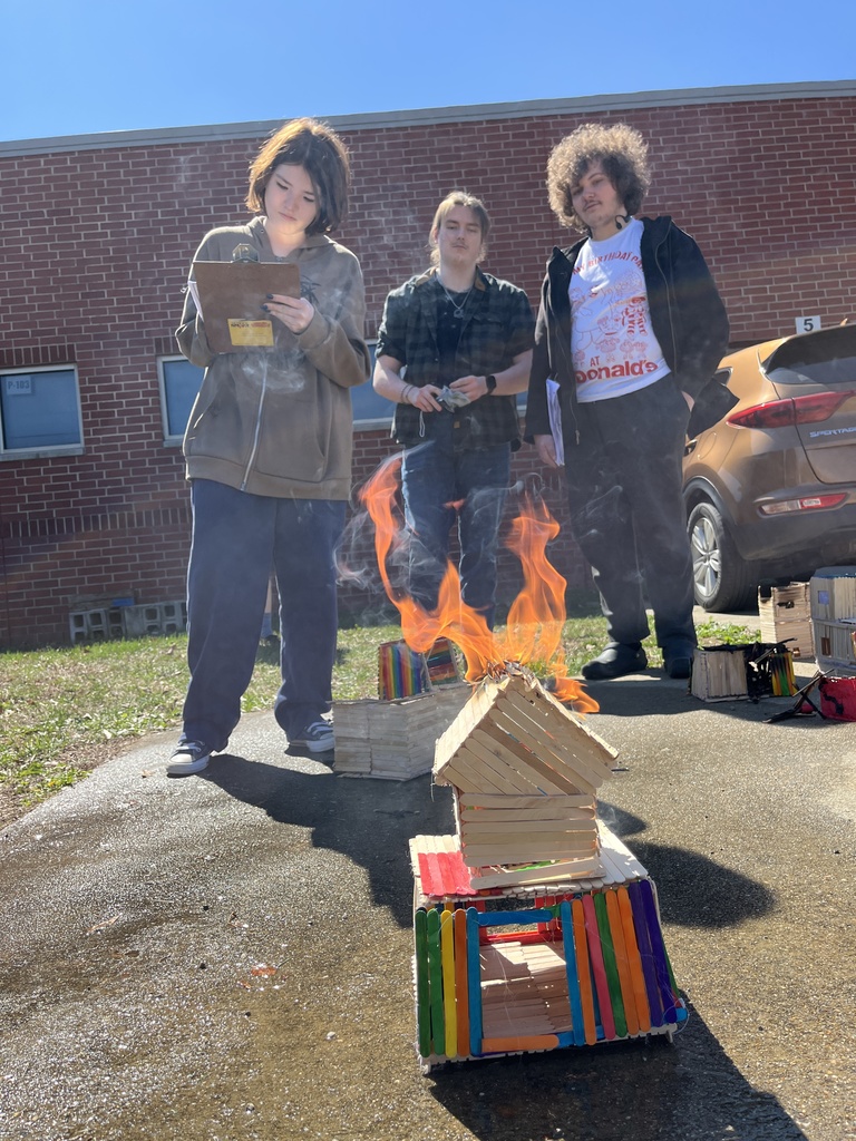 Students observe a burning popsicle house as part of a unit on arson in their forensic science class.