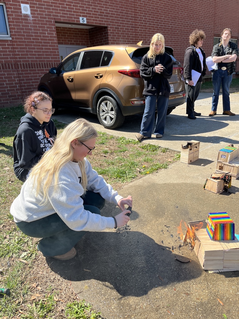 Students observe a burning popsicle house as part of a unit on arson in their forensic science class.