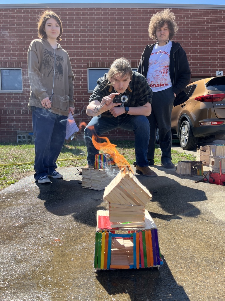 Students observe a burning popsicle house as part of a unit on arson in their forensic science class.