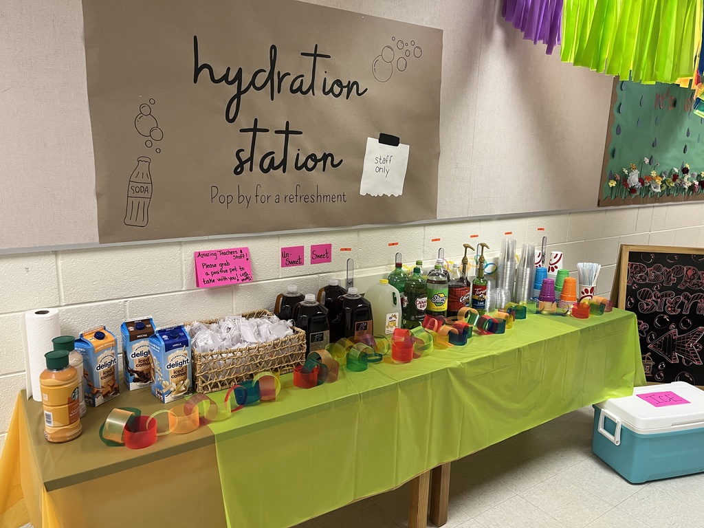 Arefresh station created by students for staff members. A sign on the walls says: hydration station. pop by for a refreshment.