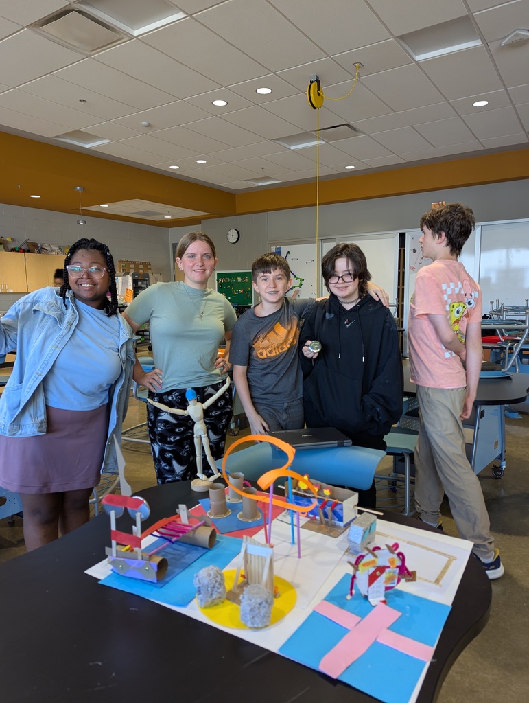 A group of students pose for a photo with roller coasters they made in the Innovation Lab. 