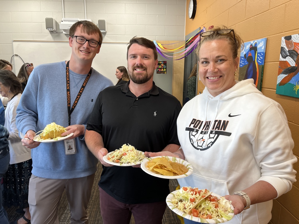 Three staff members pose for a photo at a staff appreciation taco bar at a school.