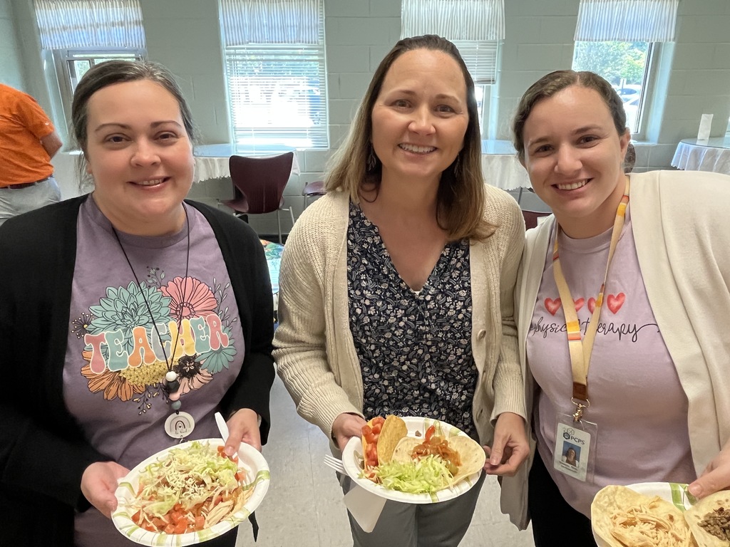 Three staff members pose for a photo at a staff appreciation taco bar lunch.