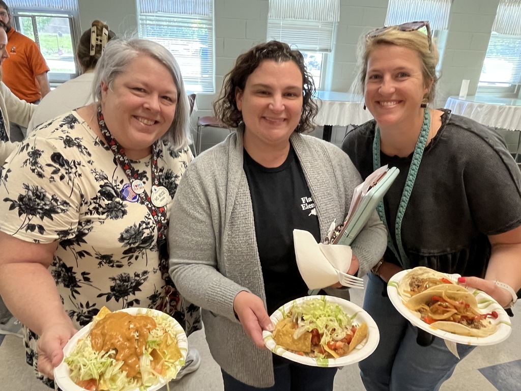 Three staff members pose for a photo at a staff appreciation taco bar lunch.