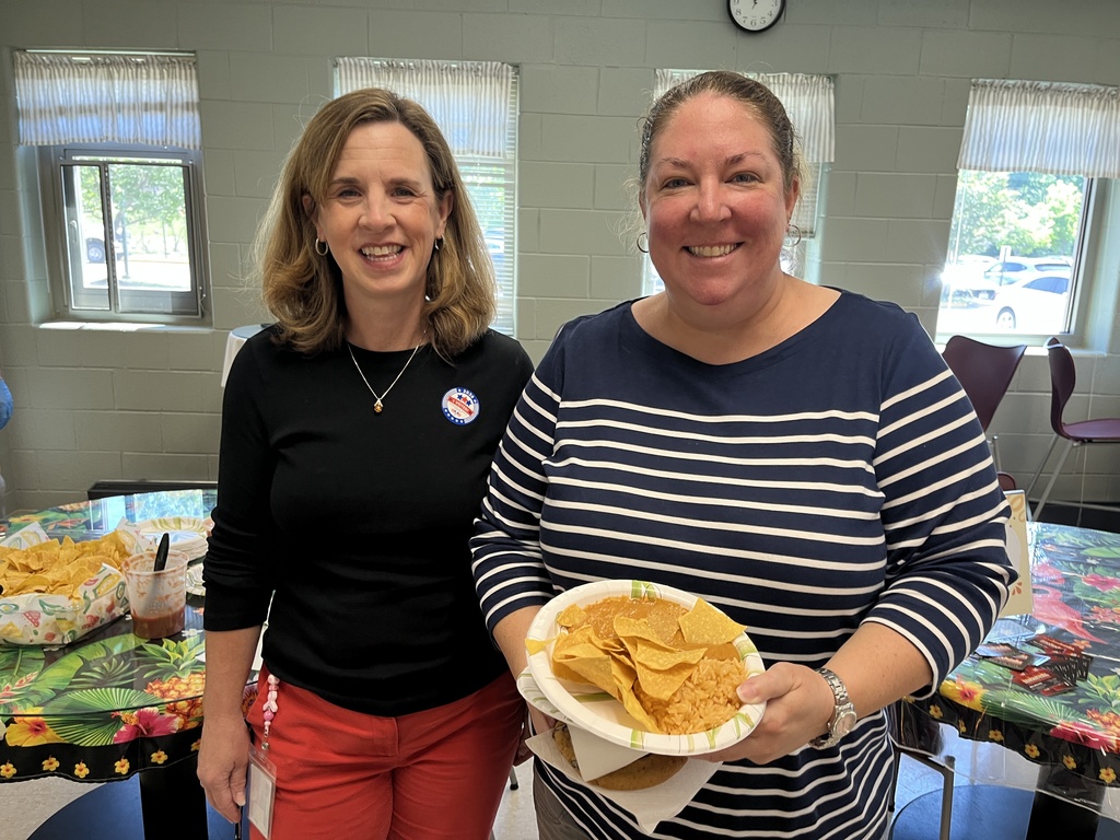 Two  staff members pose for a photo at a staff appreciation taco bar lunch.