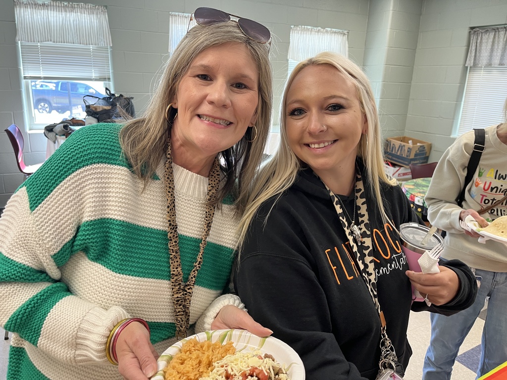 Two  staff members pose for a photo at a staff appreciation taco bar lunch.