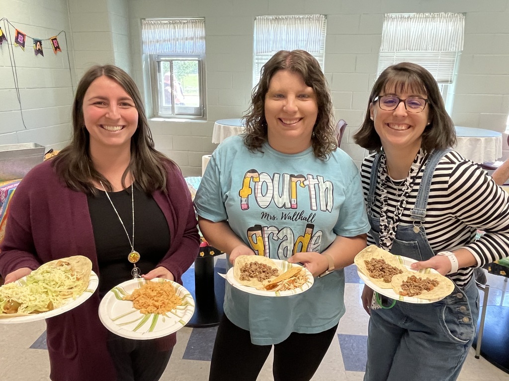 Three staff members pose for a photo at a staff appreciation taco bar lunch.