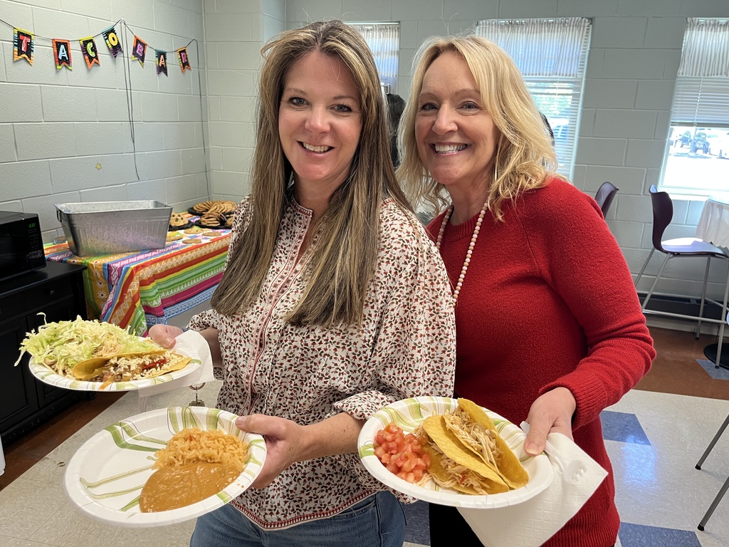 Two  staff members pose for a photo at a staff appreciation taco bar lunch.