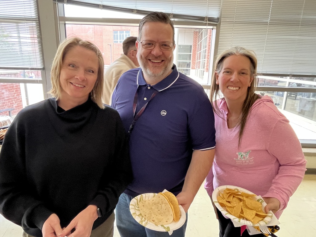 Three staff members pose for a photo at a staff appreciation taco bar lunch.