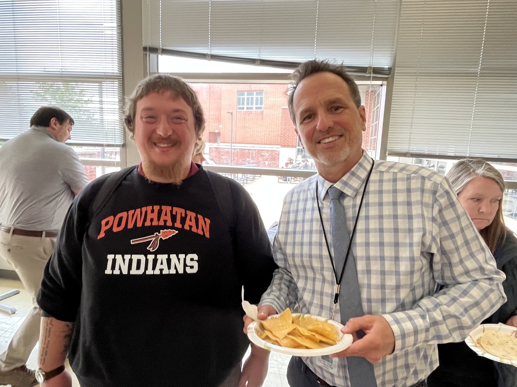Two staff members pose for a photo at a staff appreciation taco bar lunch.