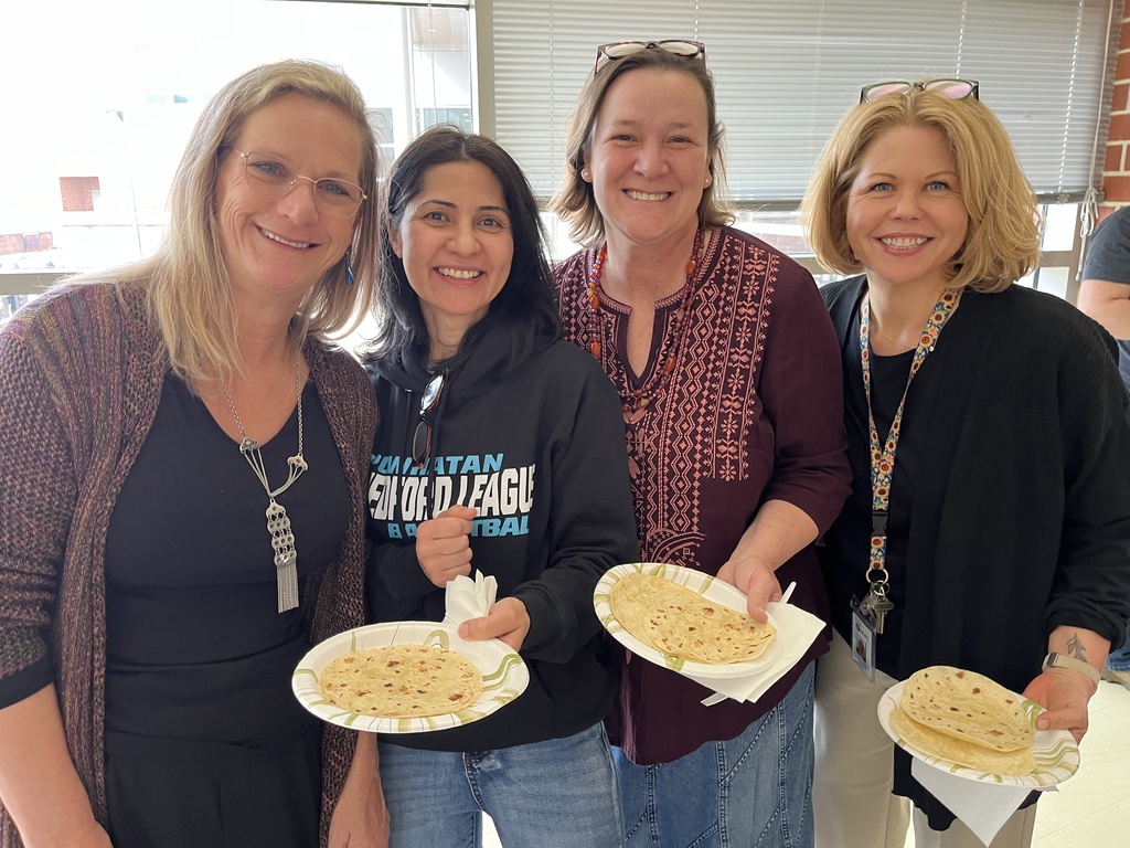 Four staff members pose for a photo at a staff appreciation taco bar lunch.