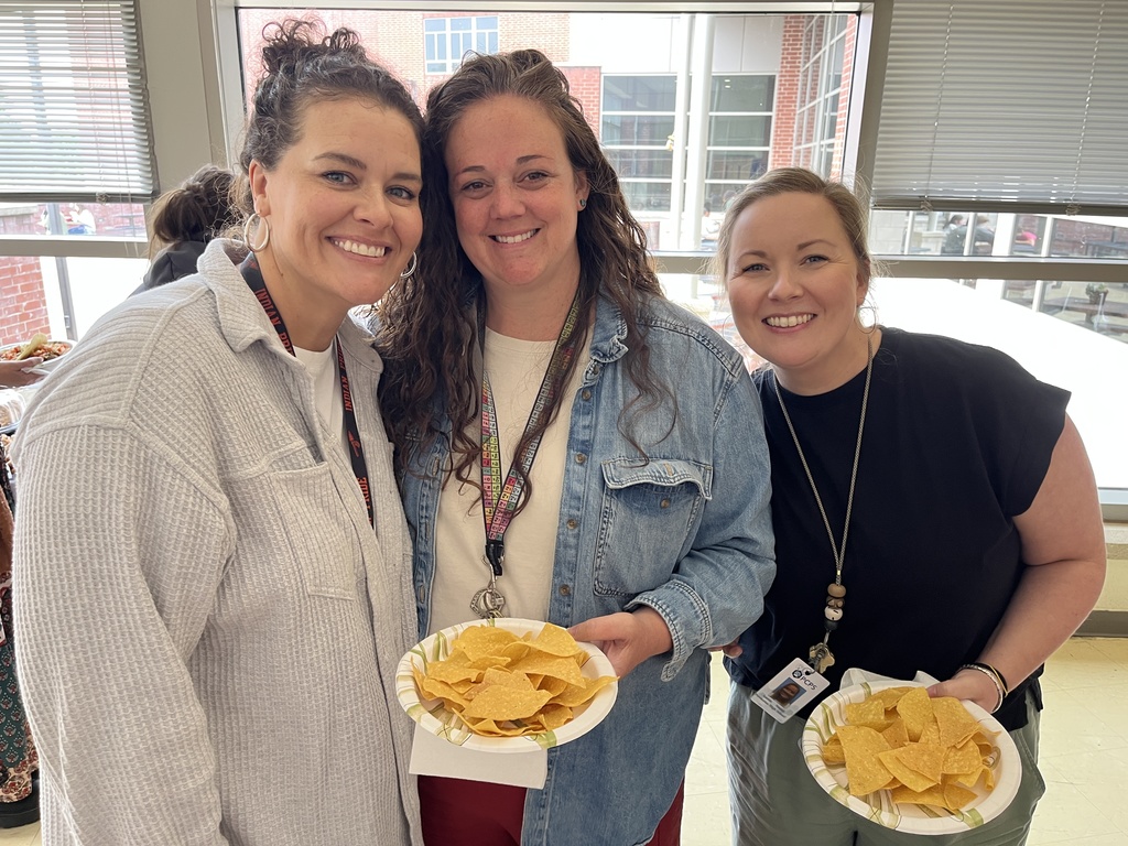 Three staff members pose for a photo at a staff appreciation taco bar lunch.