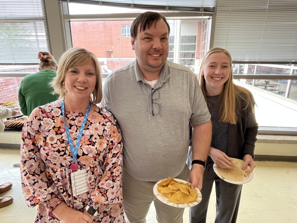 Three staff members pose for a photo at a staff appreciation taco bar lunch.
