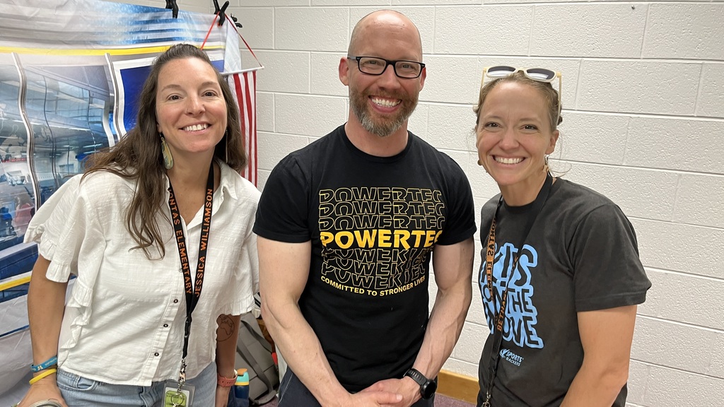 Three staff members pose for a photo at a staff appreciation taco bar. 