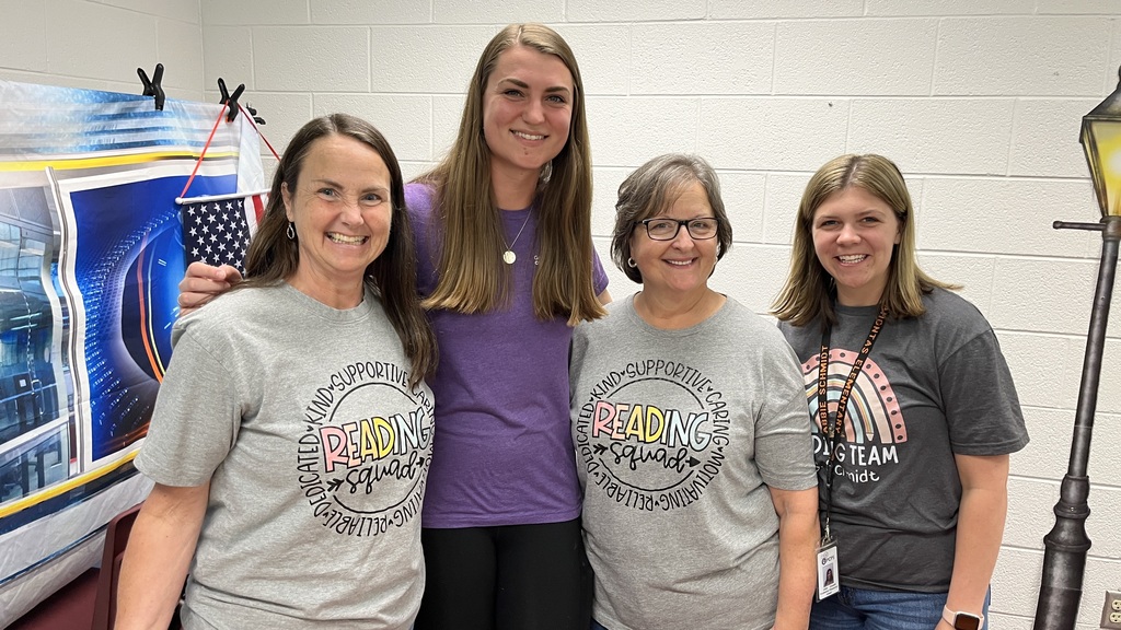 Four staff members pose for a photo at a staff appreciation taco bar. 