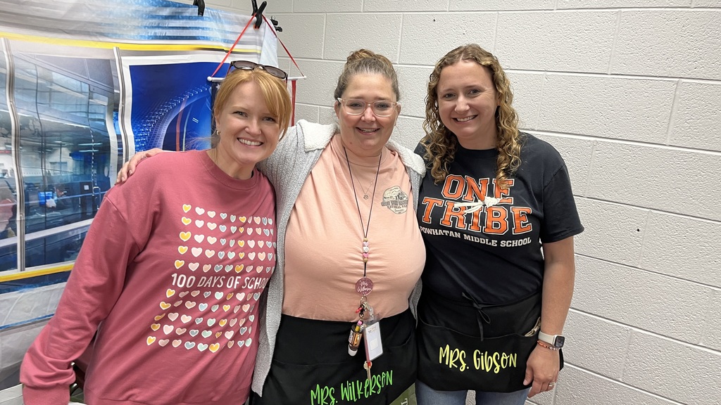Three staff members pose for a photo at a staff appreciation taco bar. 