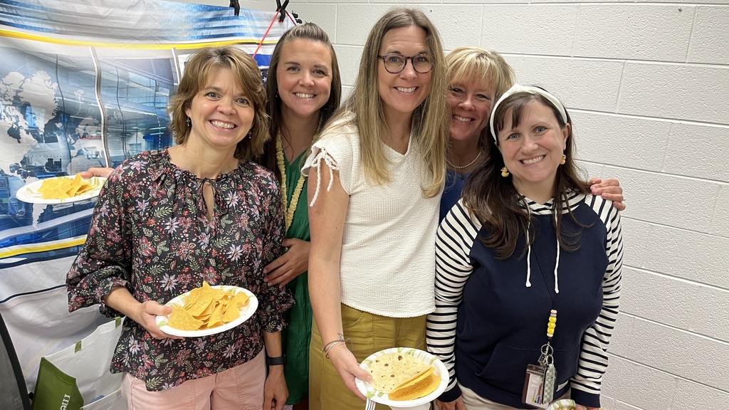 Five staff members pose for a photo at a staff appreciation taco bar. 