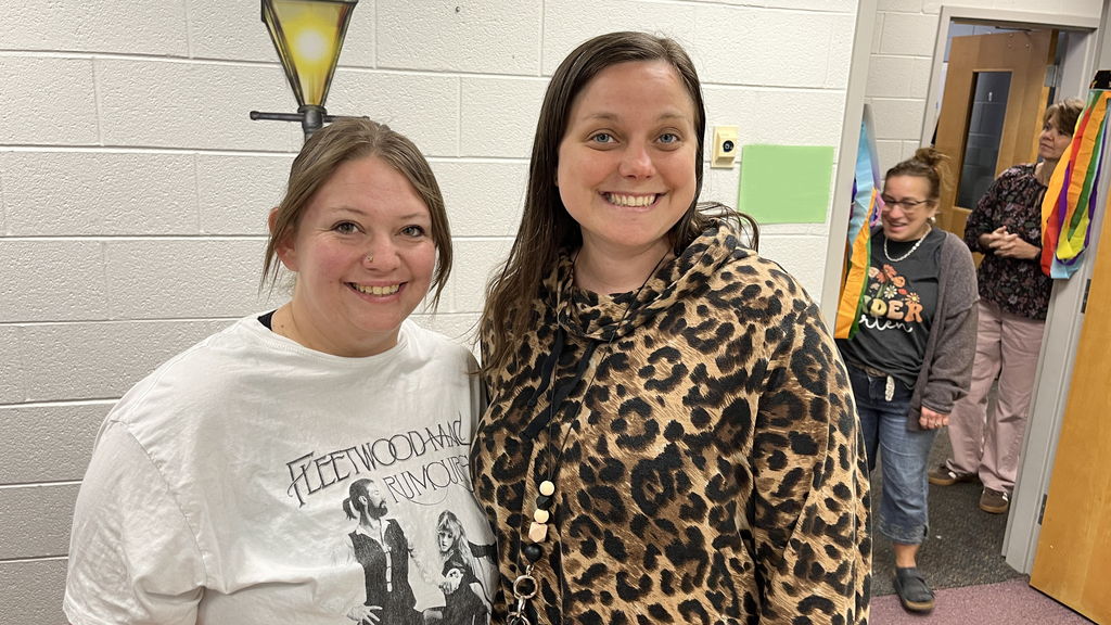 Two  staff members pose for a photo at a staff appreciation taco bar. 