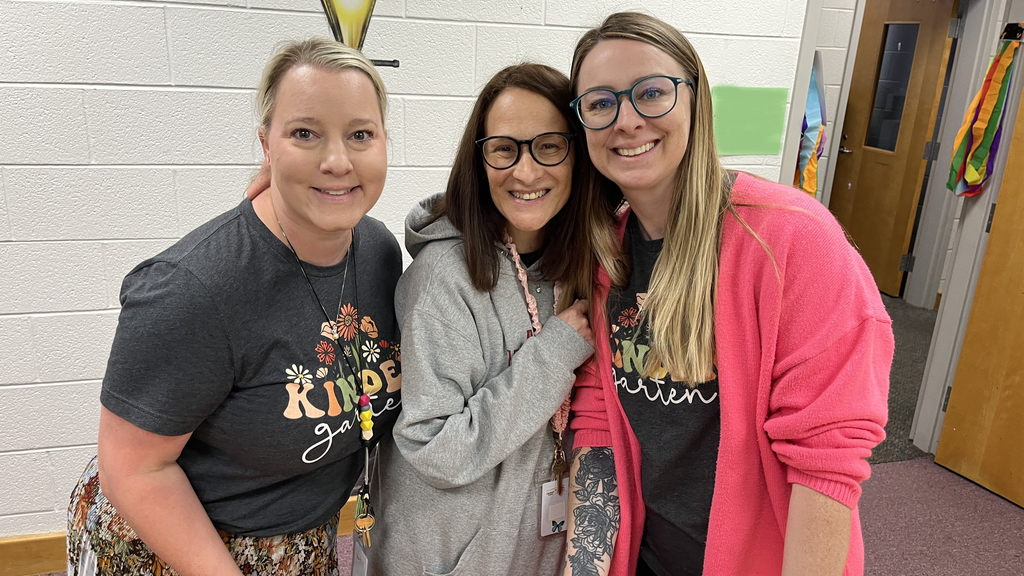 Three staff members pose for a photo at a staff appreciation taco bar. 