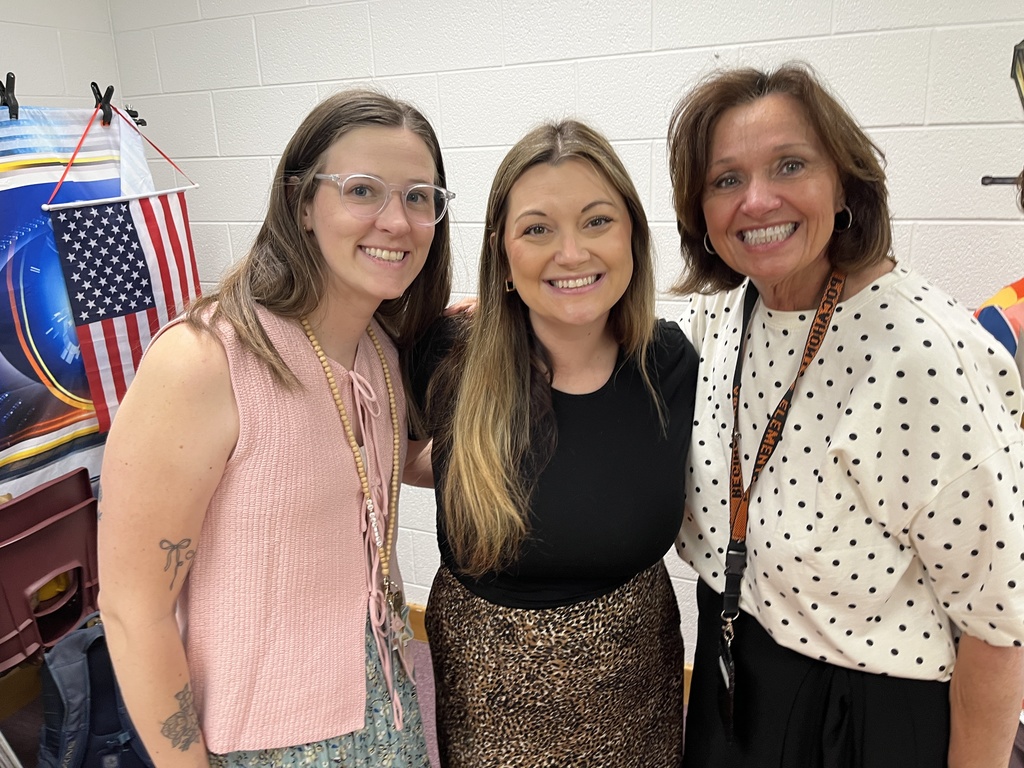 Three staff members pose for a photo at a staff appreciation taco bar. 