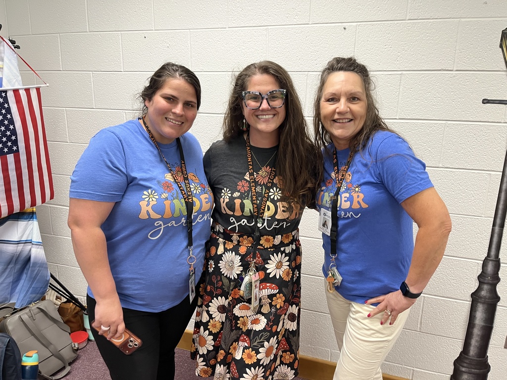 Three staff members pose for a photo at a staff appreciation taco bar. 