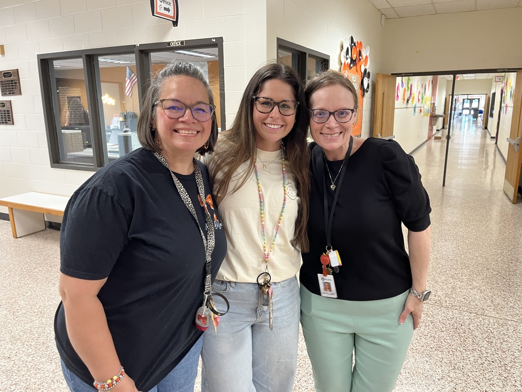 Three staff members pose for a photo at a staff appreciation taco bar at their school