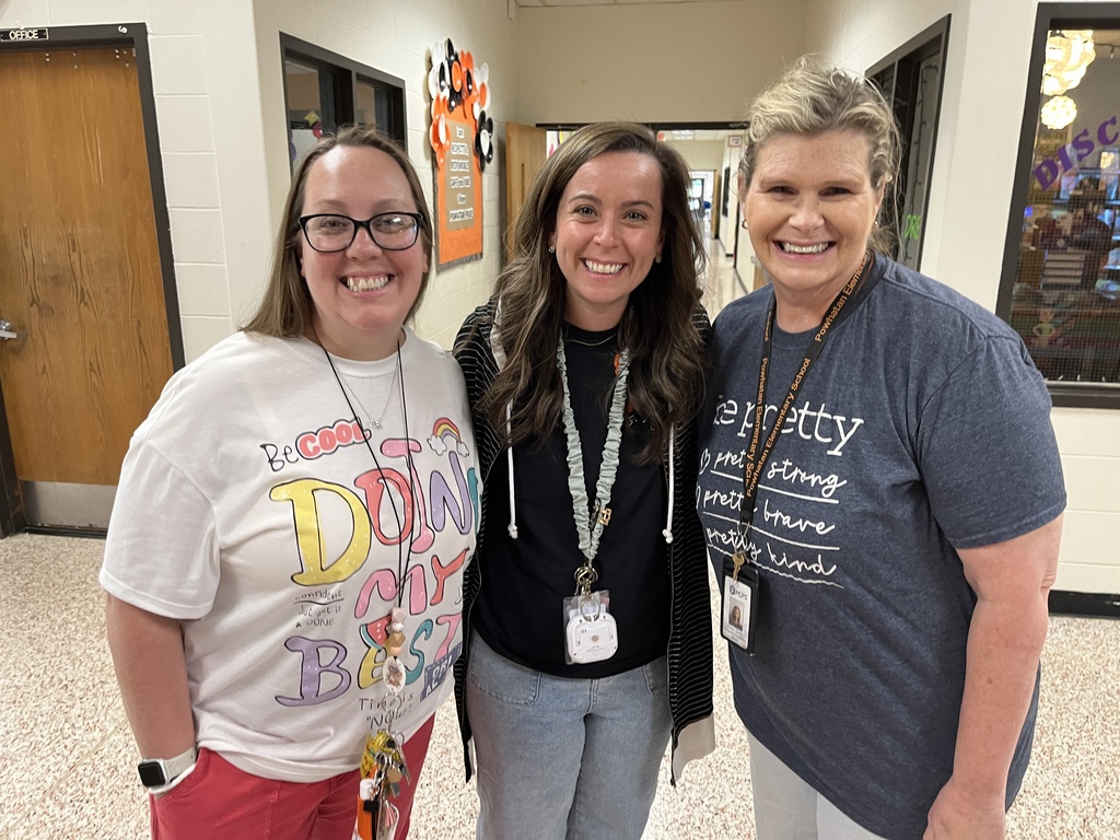 Three staff members pose for a photo at a staff appreciation taco bar at their school