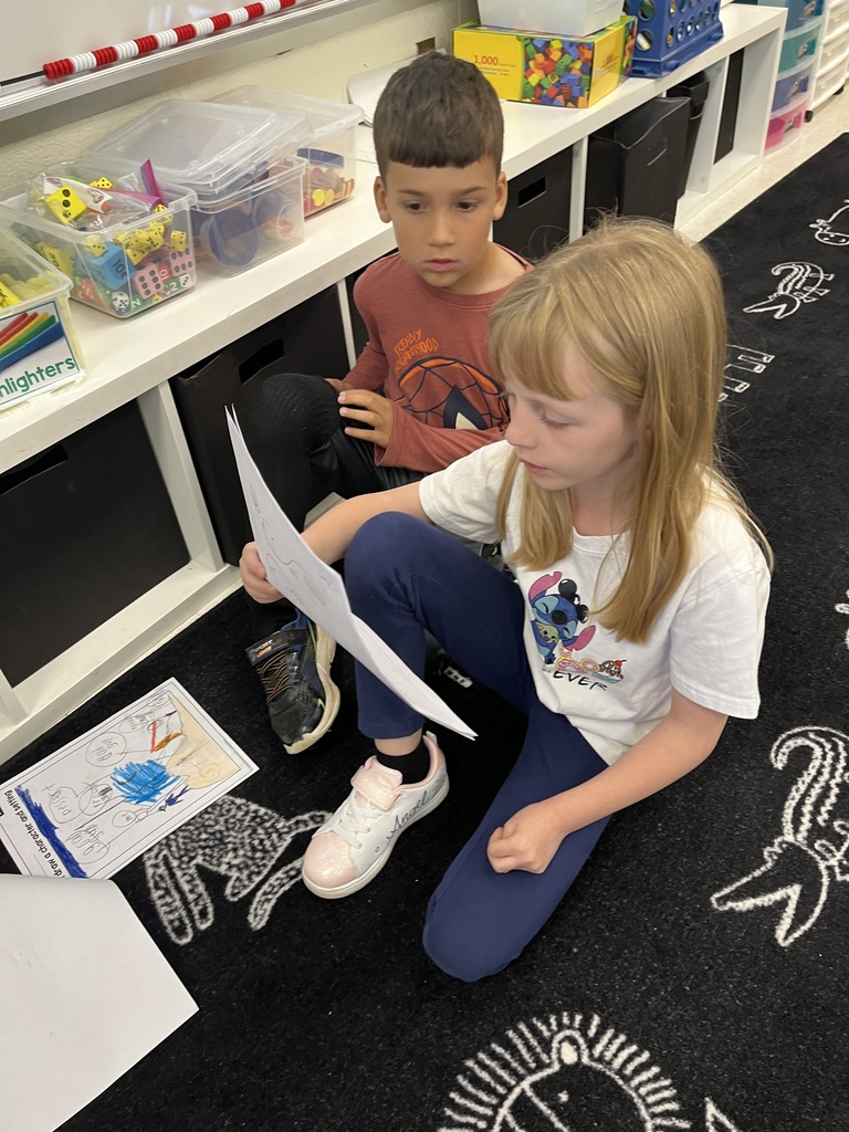 First graders in class work on a fairy tale assignment. 