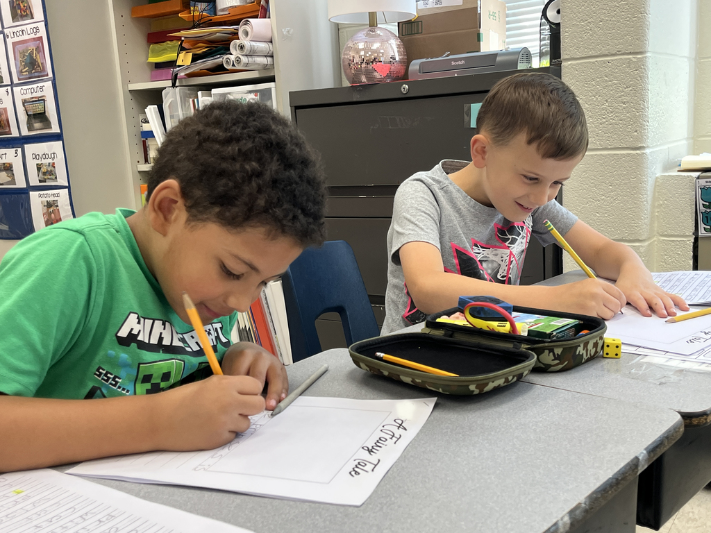 First graders in class work on a fairy tale assignment. 