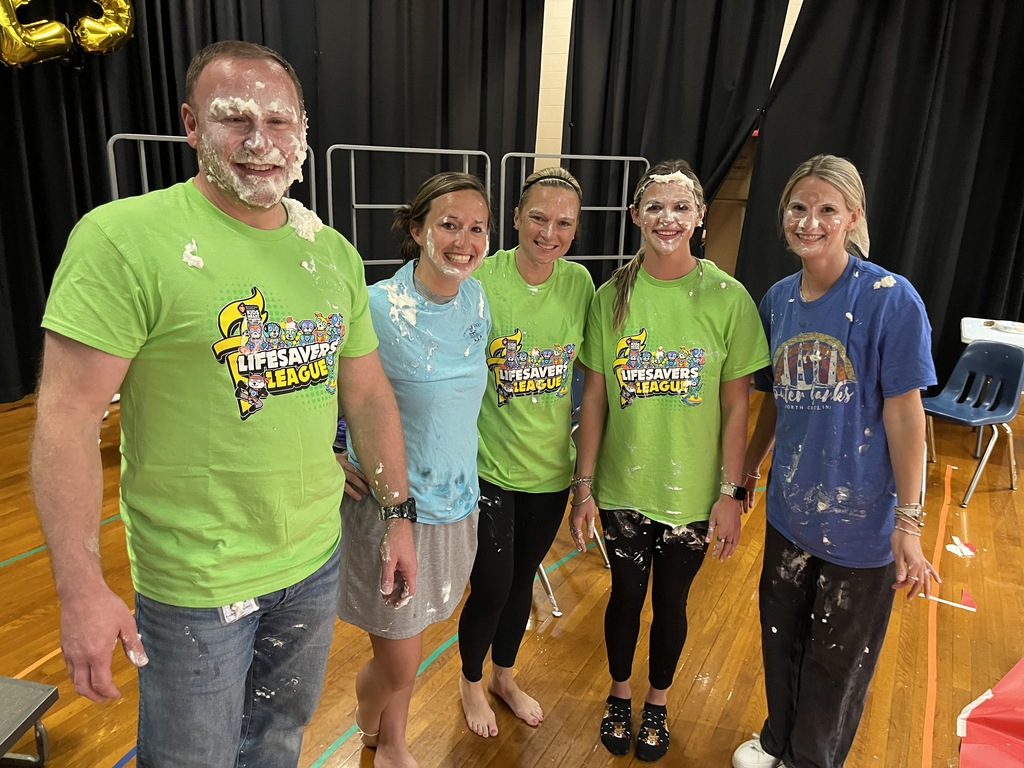 A group of school employees who participated in a pie-in-the face event pose for a photo afterward. 