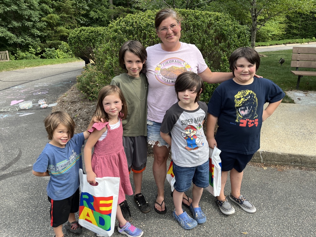 An adult and five children pose for a photo at a summer reading program kickoff event.
