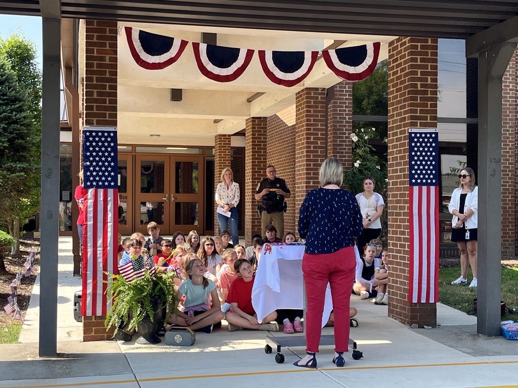 A teacher leads her elementary class in a Memorial Day ceremony.