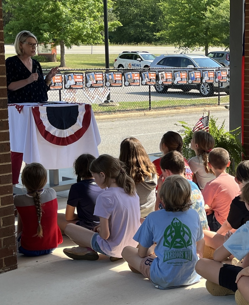 A teacher leads her elementary class in a Memorial Day ceremony.