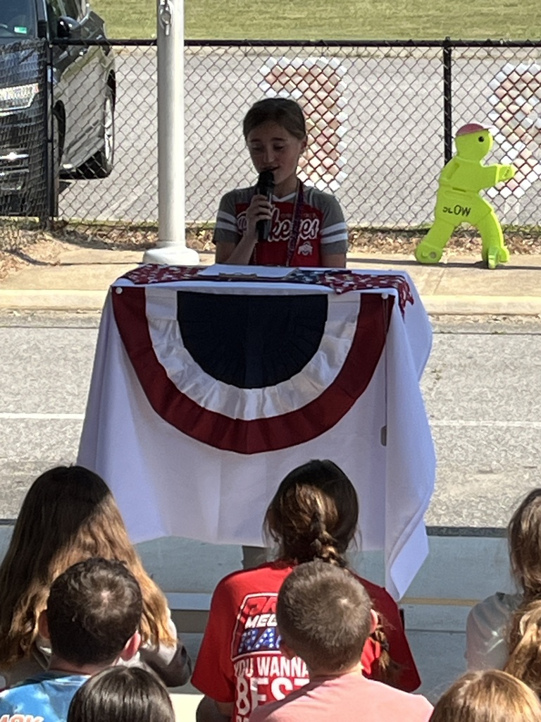 A student reads a selection during a Memorial Day ceremony.