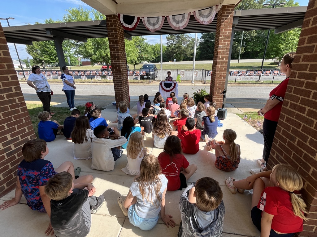 A teacher leads her elementary class in a Memorial Day ceremony.