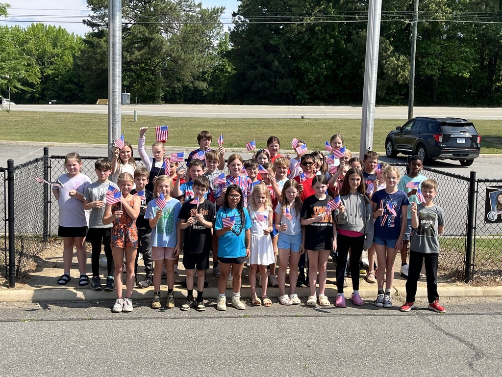 A large group of students  pose for a photo following a Memorial Day ceremony.