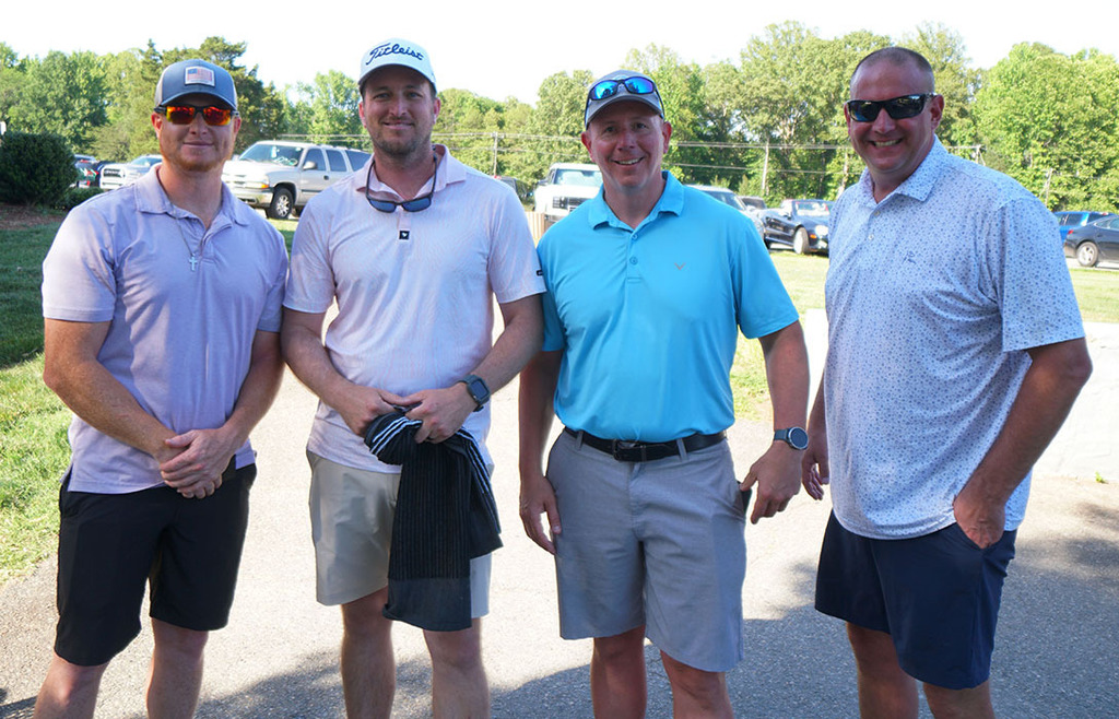 The 2nd-place 4-person team poses for a photo at the end of a golf tournament. 