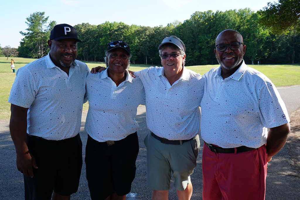 The third-place 4-person team poses for a photo at the end of a golf tournament. 