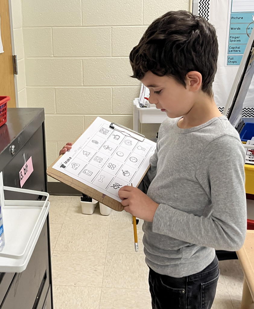 A student works at a literacy station  to practice long vowel sounds .
