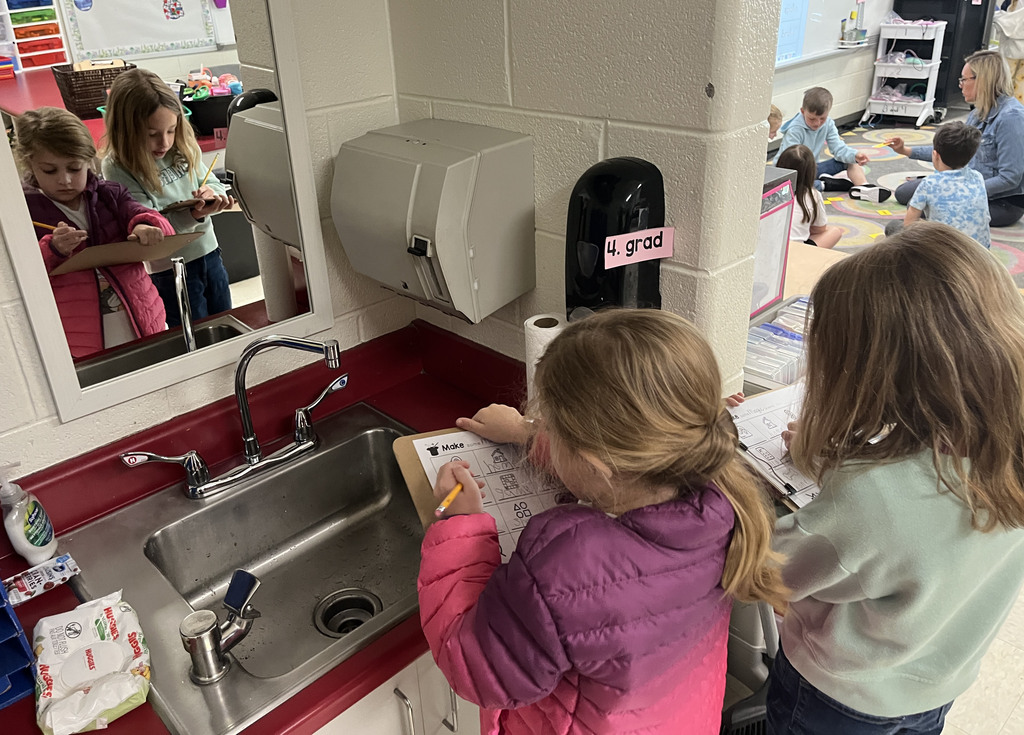Students work at a literacy station  to practice long vowel sounds .