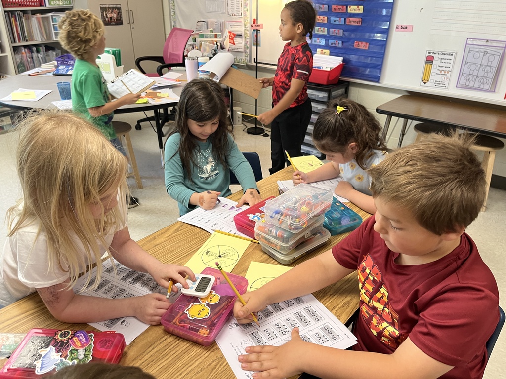 Students work at a literacy station  to practice long vowel sounds .