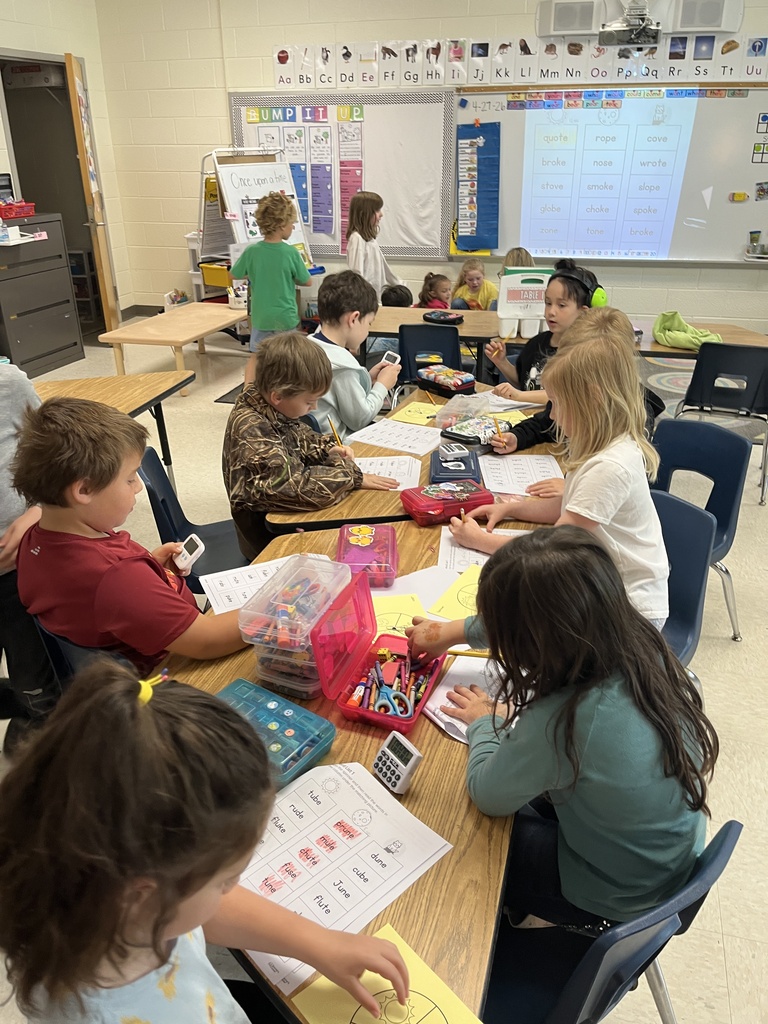 Students work at a literacy station  to practice long vowel sounds .
