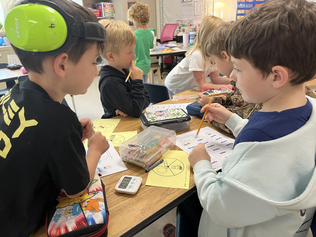 Students work at a literacy station  to practice long vowel sounds .