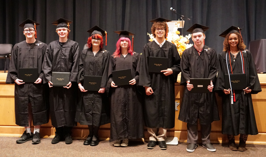 A group of summer graduates pose with their newly awarded diplomas.