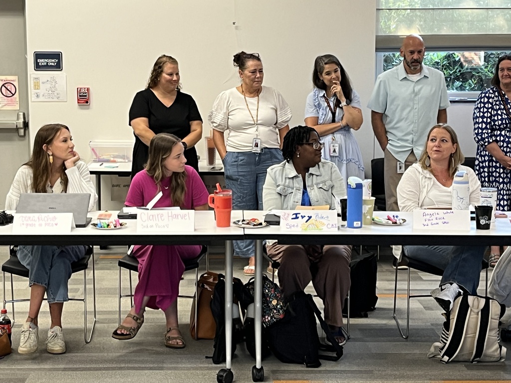 A group of new teachers sit through orientation with existing staff members.